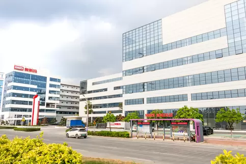 Panoramic view of the main entrance of the west gate of the Osm Intelligent Equipment Manufacturing Park, showcasing the exterior of a modern intelligent factory building that blends industrial technology with architectural design aesthetics, reflecting t