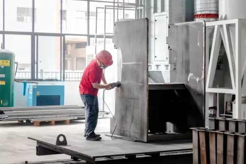 Live footage of OSM bending machine precision manufacturing process: Professional technicians perform sandblasting surface treatment on the machine frame, using an efficient and environmentally friendly process to remove the oxide layer and enhance coatin