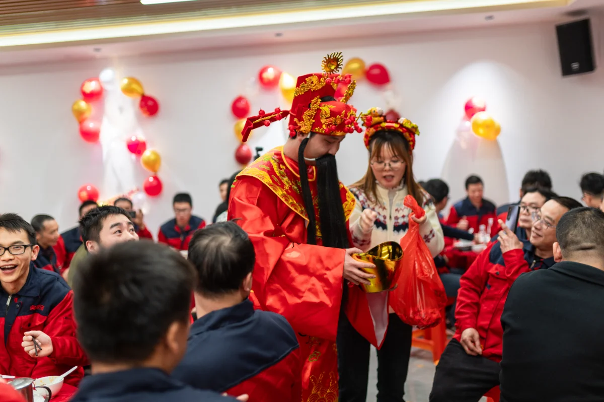OSM 2026 Annual Meeting highlights: employees in traditional costumes celebrate with red balloons. This manufacturing company event showcases team spirit and company culture.