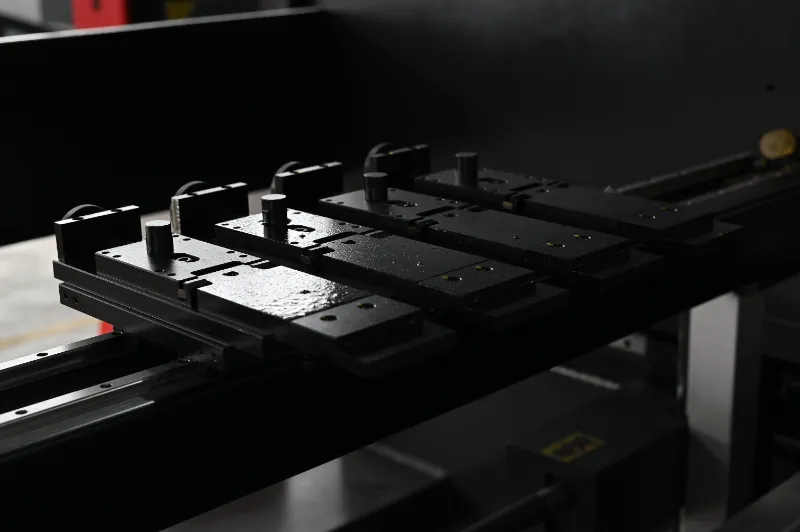 Close-up of OSM press brake back gauge system automatic stop finger, highlighting efficient and precise material positioning device.