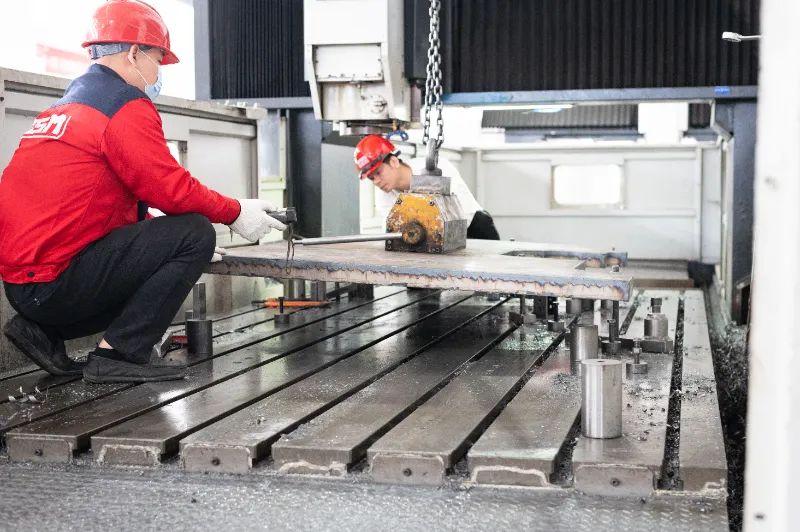 OSM worker assembling a CNC press brake in the production workshop, highlighting precision manufacturing and efficient assembly processes.