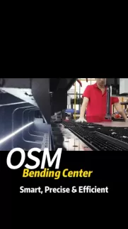 OSM Bending Center showcasing smart and precise manufacturing. A worker in a red shirt operates advanced machinery for efficient metal bending and production.