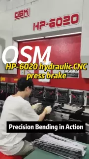 OSM HP-6020 hydraulic CNC press brake in action. This industrial metalworking machine features precision bending capabilities, operated by a technician for high-accuracy sheet metal fabrication tasks.
