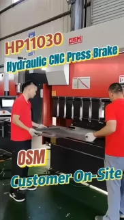 Two Operators, One Perfect Bend — OSM HP11030 in Action! DSM HP11030 hydraulic CNC press brake in action. Two operators load sheet metal for precision bending. This industrial machine ensures high accuracy for metal fabrication tasks.